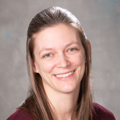 Studio portrait of Becca Wetzel facing the camera against a soft gray background.